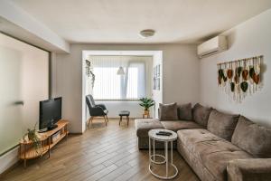 Una sala de estar con un sofá y un televisor. en Central flat Wi-Fi & streaming, en Varna