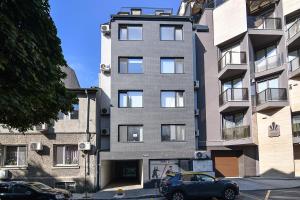 un coche aparcado delante de un edificio alto en Central flat Wi-Fi & streaming, en Varna