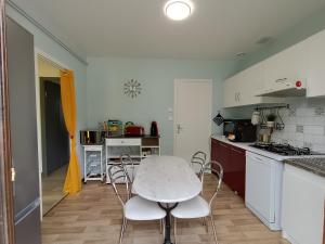 a kitchen with a table and chairs in a room at Maison entière 65 m² 5 personnes + jardin au calme in Saint-Aulaire