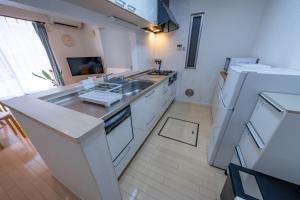 a white kitchen with a sink and a refrigerator at HOTEL Flag Tokyo - Vacation STAY 29759v in Tokyo