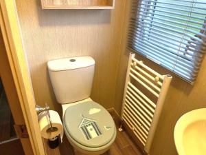 a bathroom with a toilet with a house painted on it at Memories Made, Quiet Holiday, Green Lawns in Selsey +10 photos