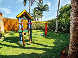 a playground with a ladder and a slide in the grass at Pousada João Fernandes in Búzios