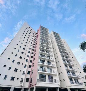 Dos grandes edificios de apartamentos blancos contra un cielo azul en The Perfect Cozy Home For You, en Dar es Salaam