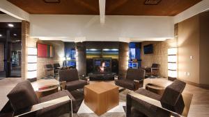 a lobby with chairs and a fireplace and a tv at Best Western Plus University Inn in Moscow