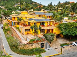 an overhead view of a yellow house on a hill at Pousada João Fernandes in Búzios