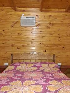 een slaapkamer met een bed met airconditioning aan de muur bij Cabañas Libertad en Misiones in Puerto Bossetti