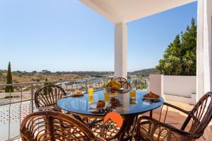 einen blauen Tisch mit Stühlen und Essen auf einem Balkon in der Unterkunft #185 Private Marina and Ocean View with Pool in Albufeira