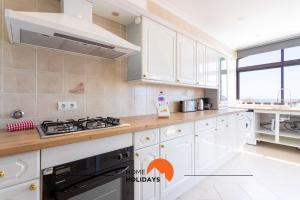 a kitchen with white cabinets and a stove top oven at #185 V3 Laranjeiras by Home Holidays in Páteo