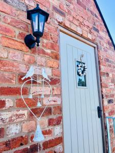 The Honeysuckle Coop في غرانثام: مبنى من الطوب مع باب أبيض ومصباح