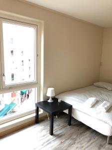 um quarto com uma cama e uma grande janela em Guesthouse - Oslo Centrum em Oslo