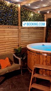 a jacuzzi tub in a room with a bench and a chair at Sèid Bò - Sleeps 6 - NEW Private 6 Person HotTub Available in Burnfoot