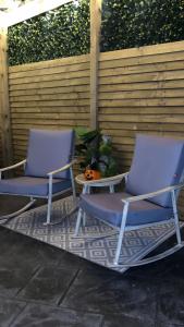 two blue chairs and a table on a patio at Sèid Bò - Sleeps 6 - NEW Private 6 Person HotTub Available in Burnfoot