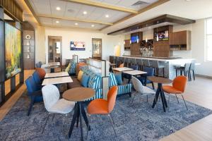 um restaurante com mesas e cadeiras e um bar em Hyatt House Vacaville em Vacaville