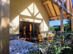 a patio with a tub and a table and chairs at Alsace Chalet & Spa Meyer-Krumb in Sigolsheim