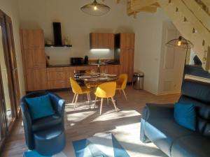 cocina y sala de estar con mesa y sillas en Alsace Chalet & Spa Meyer-Krumb, en Sigolsheim
