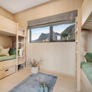 a bedroom with two bunk beds and a window at NEW! Luxury Cabin in beautiful Lofoten in Kleppstad