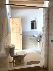 a bathroom with a toilet and a sink at Depa Carpena playa Punta Veleros in Los Órganos