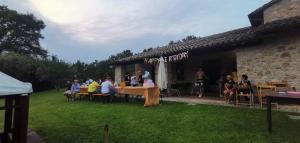 a group of people sitting at tables in a yard at Il Vignale in Massa Martana
