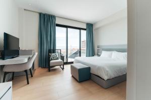 a bedroom with a bed and a desk and a computer at Elements Hotel & Shops Curaçao in Willemstad