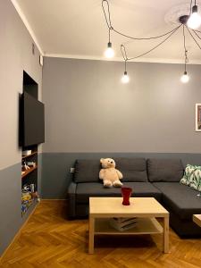 a teddy bear sitting on a couch in a living room at REAL VIP Hostel in Krakow