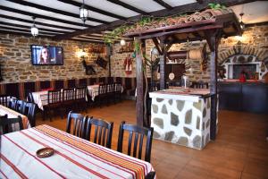 a dining room with tables and chairs and a tv at GERANA HOUSE in Kilifarevo