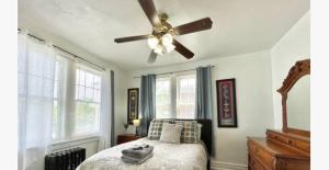1 dormitorio con ventilador de techo y 1 cama en (55.1S) Experience a True STL Visit!, en Saint Louis