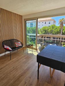 sala de estar con mesa y ventana grande en Studio Le Santa-Maria - Frejus Plage en Fréjus