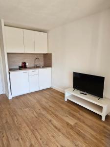 an empty living room with a flat screen tv at Studio Le Santa-Maria - Frejus Plage in Fréjus