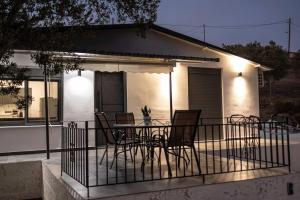 a patio with chairs and a table in front of a house at Domus Villa in Ermioni