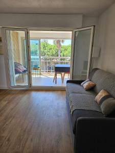 a living room with a couch and a sliding glass door at Studio Le Santa-Maria - Frejus Plage in Fréjus