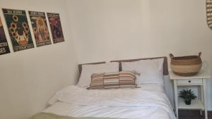a white bed with a pillow and posters on the wall at Luxury peaceful, free parking in Rechovot