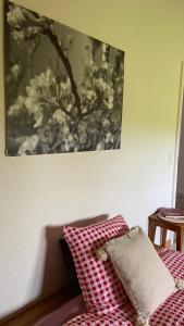a bed with red and white pillows and a picture on the wall at Naturnahe Familienwohnung in Rüschegg-Graben