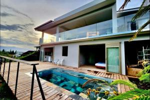 a house with a swimming pool in front of it at Nature Villa with Pool Thaiti in Punaauia
