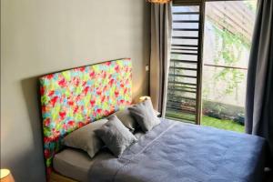 a bedroom with a blue bed with a large window at Nature Villa with Pool Thaiti in Punaauia