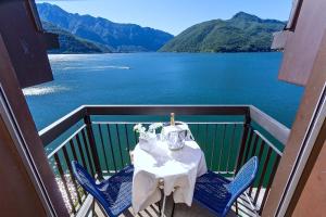 a table on a balcony with a view of a lake at Hotel Riviera in Melide