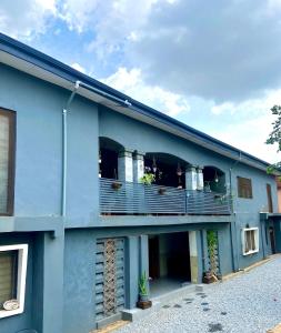 un edificio azul con un balcón con gente en él en Bruks Guest House, en Kumasi