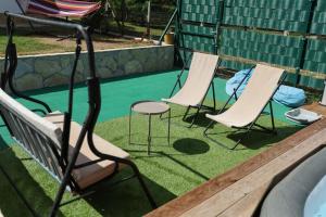 a group of chairs sitting next to a pool at Vila Banstolija in Velika Remeta +33 photos