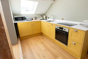 a kitchen with yellow cabinets and a sink at Glyder - Snowdonia, North Wales in Bethesda