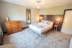 a bedroom with a bed and a dresser and a mirror at Glyder - Snowdonia, North Wales in Bethesda