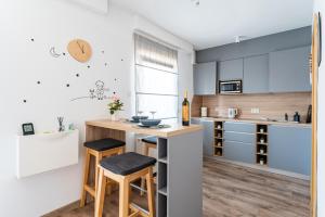a kitchen with a counter and stools in a room at Studio apartman the little Prince in Bjelovar