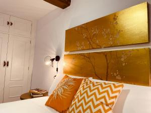 a bedroom with a bed with a large painting on the wall at Alojamiento Singular Casa Haraiz in Jaraiz de la Vera