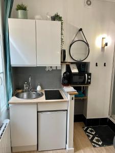 a small kitchen with a sink and a microwave at Le Cosy, charmant studio centre ville in Rennes