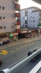 a city street with buildings and a road with a car at Apartmani Borko 1-1 in Loznica