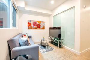 a living room with a couch and a tv at Spacious 2BR Apartment - Stunning View of CN Tower in Toronto