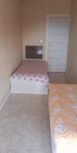 1 Schlafzimmer mit 2 Betten und einem Schrank mit einer Tür in der Unterkunft Casa com Belas vistas - Muriqui in Mangaratiba