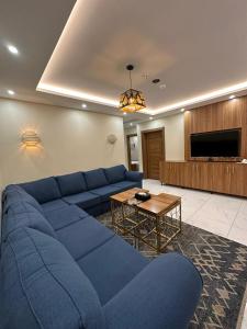 uma sala de estar com um sofá azul e uma mesa em منازل اليتا em Ar Rabwah
