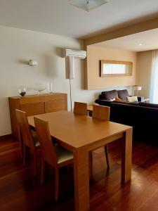 - un salon avec une table en bois et un canapé dans l'établissement E&M Apartment Luz, à Luz