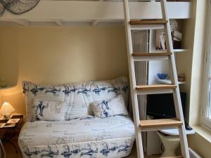 ein Schlafzimmer mit einem Etagenbett und einer Leiter in der Unterkunft Studio cosy à 50m de la plage, Cabourg, 3 pers - FR-1-487-330 in Cabourg