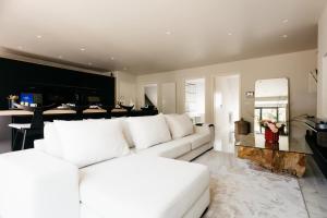 - un salon avec un canapé blanc et un miroir dans l'établissement The Edgewater Suites - RIVERSIDE, à Namur