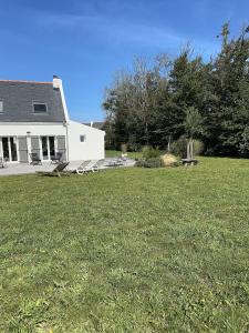 ein weißes Haus mit einem Hof mit einem Grasfeld in der Unterkunft Maison spacieuse à deux pas de la plage … in Le Palais